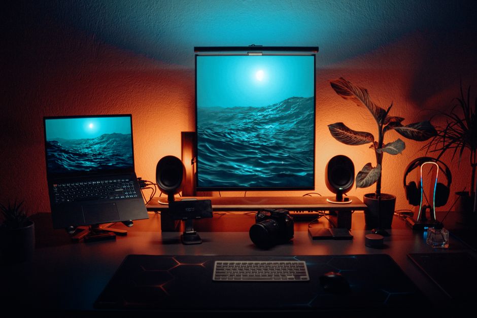 Stylish office setup featuring dual monitors, tech gadgets, and ambient lighting.