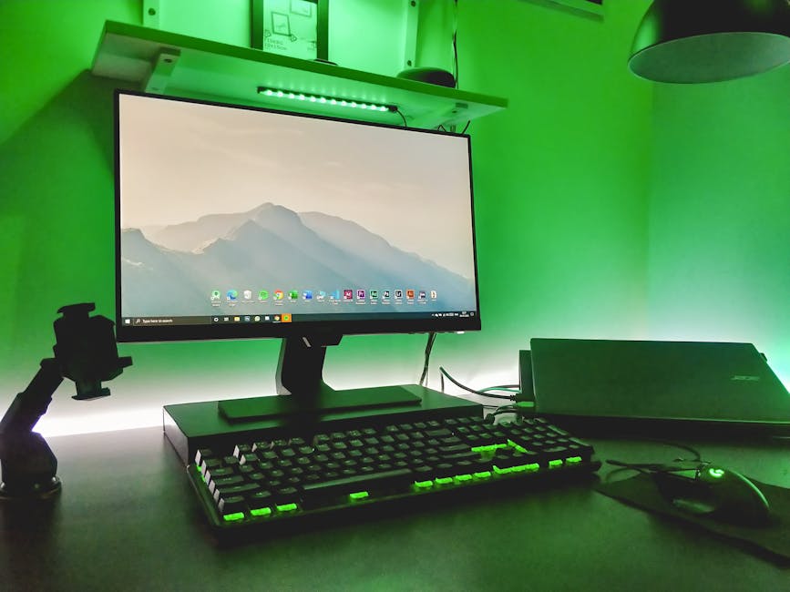 Stylish workspace featuring a desktop, keyboard, and ambient green LED lighting